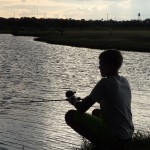 Boy fishing at sunset
